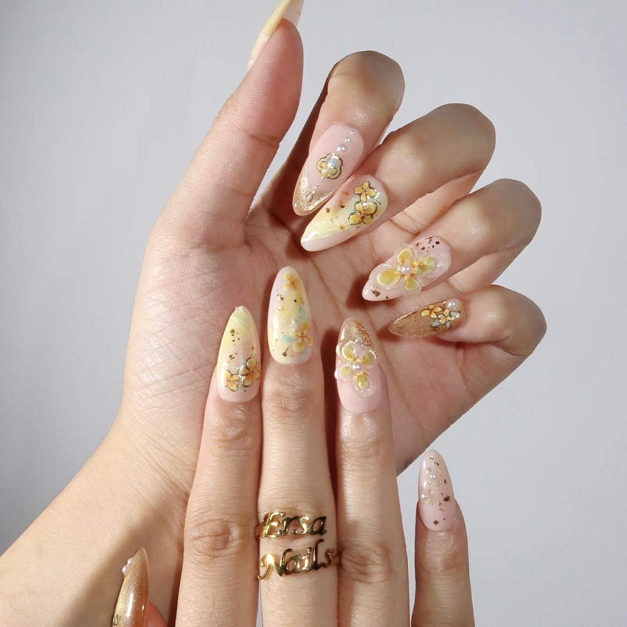 Hand with decorative floral nail art on a plain background